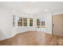 Bright living room boasts hardwood floors, large windows, elegant chandelier and a sliding glass door to the outside at 130 Valley Glen Dr, Troutman, NC 28166