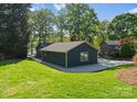 Landscaped backyard with green grass, trees, and beautiful lake views at 141 Baywatch Dr, Mooresville, NC 28117