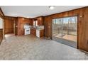 The kitchen showcases warm wood cabinets and a sliding door leading to a private outdoor deck at 207 Bright Ave, Bessemer City, NC 28016