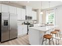 Bright kitchen features white cabinets, stainless appliances and island seating at 2159 Primm Farms Dr # C, Charlotte, NC 28216