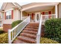 Inviting front porch with brick steps and white railings, complemented by well-manicured landscaping at 292 Miller Farm Rd, Statesville, NC 28625