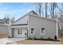 Charming single Gathering home with light grey and beige vinyl siding, black trim, and welcoming covered entryway at 935 Junius St, Gastonia, NC 28052