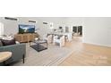 Bright open concept living room with white walls, light wood floors, and views into the kitchen and dining areas at 935 Junius St, Gastonia, NC 28052