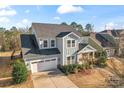 An eye-level, aerial view of a two-story home showcasing the roof, landscaping, and neighborhood at 12018 Grey Partridge Dr, Charlotte, NC 28278