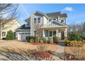 Charming two-story home with light blue siding, a manicured front yard, and inviting front porch at 12018 Grey Partridge Dr, Charlotte, NC 28278