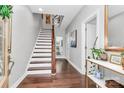 Inviting foyer features hardwood floors, a staircase with white risers, and neutral wall paint at 1244 Madison Towns Ln, Charlotte, NC 28209
