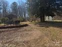 Unkept backyard with outbuildings and overgrown landscaping, a blank canvas to create your dream oasis at 128 Trexler Ave, Mount Holly, NC 28120