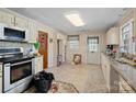 This is a kitchen with tile floors, light colored cabinets, stainless steel appliances, and a door to the outside at 1874 Mcilwain Rd, Lancaster, SC 29720