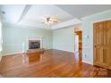 Bright living room boasts a fireplace, ceiling fan, and beautiful hardwood floors at 1910 Connemara Ct, Gastonia, NC 28054