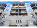 Eye-level view of the condo building's facade with balconies, brick accents, and meticulously maintained landscaping at 2401 Euclid Ave # 306, Charlotte, NC 28203