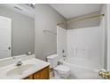 Bathroom featuring a vanity with storage, toilet, and bathtub with shower and tiled surround at 3230 Richway Ct, Charlotte, NC 28216