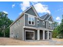 Two-story gray townhouse showcasing the attached garage and covered entryway with white pillars at 507 Bowman Rd, Charlotte, NC 28217