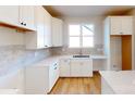 Bright kitchen featuring white cabinets, light countertops, a modern sink, and wooden floors at 602 Banter Ln # 28, Cramerton, NC 28032