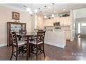 Eat-in kitchen features white cabinets, granite countertops, pendant lighting, and stainless steel appliances at 8418 Loxton Cir, Charlotte, NC 28214
