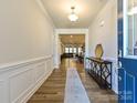 Bright entryway with hardwood floors, decorative molding, console table, and an open view to the living spaces at 9432 Liberty Hill Dr, Mint Hill, NC 28227