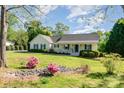 Inviting single-story home with a front porch, landscaped garden, and lush lawn at 202 Oakwood St, Stanfield, NC 28163