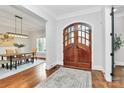 Inviting foyer with arched wood doors, hardwood floors, and view into dining room at 2114 Garden View Ln, Weddington, NC 28104