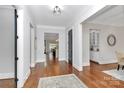 Spacious hallway with hardwood floors, white trim, and views of other rooms at 2114 Garden View Ln, Weddington, NC 28104