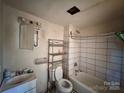 Functional bathroom with a tub-shower combo, toilet, and sink, presenting a blank canvas for renovation at 2124 W C St, Kannapolis, NC 28081