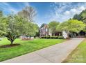 Classic red brick home with a long driveway and expansive front yard at 2217 Heath Lake Dr, Mint Hill, NC 28227