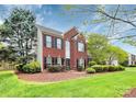 Beautiful red brick home with lush landscaping and a well-maintained green lawn at 2217 Heath Lake Dr, Mint Hill, NC 28227