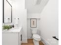 Half bathroom with white cabinet, marble countertop, black hardware, and wood-look floors at 2965 Beech Nut Rd, Charlotte, NC 28208