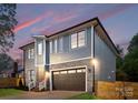 Side view of home with two stories, gray siding, black windows, and a two-car garage at 2965 Beech Nut Rd, Charlotte, NC 28208