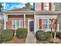 Inviting entryway with a black front door, red shutters, and trimmed shrubbery at 3099 Windsor Trace Dr, Fort Mill, SC 29707