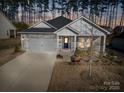 Charming single-Gathering home featuring stone accents, a two-car garage, and a welcoming front porch at 4321 Duplin Dr, Charlotte, NC 28214