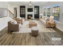 Bright living room featuring hardwood floors, a fireplace, and large windows at 6234 Artigas Dr, Fort Mill, SC 29707