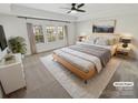 Cozy main bedroom with a ceiling fan, large windows, and a plush rug at 6234 Artigas Dr, Fort Mill, SC 29707