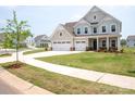 Charming two-story home featuring a three-car garage and covered front porch at 730 Autumn Sage Dr, Indian Trail, NC 28079