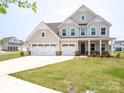 Charming two-story home featuring a three-car garage and covered front porch at 730 Autumn Sage Dr, Indian Trail, NC 28079