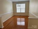 A bright dining room with hardwood floors, a chandelier and lots of natural light at 1043 Boxelder Ln, Charlotte, NC 28262