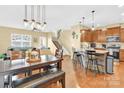 Open-concept dining area with wood floors and modern lighting fixtures adjacent to kitchen at 105 Clarendon St # C, Mooresville, NC 28117