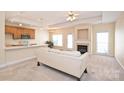 Open-concept living room with fireplace flows into kitchen area; features neutral carpet and ample natural light at 1131 Curry Way # 69, Matthews, NC 28104