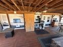 Inviting covered deck with an outdoor kitchen featuring a grill, oven, microwave and a tv at 114 Dove Ln, New London, NC 28127