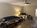 Spacious living room with a comfy blue sectional, modern ceiling fan and wood flooring at 1301 N Mcdowell St, Charlotte, NC 28205