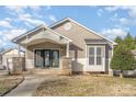 Front view of a cozy home, highlighting the covered entrance with stone accents, a small side window, and charming curb appeal at 1720 Dewberry Pl, Salisbury, NC 28146