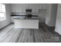 Modern kitchen with white cabinets, gray counters, and a large island at 232 Sugar Hill Rd, Troutman, NC 28166