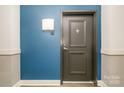 A stylish front door is set against a blue accent wall, creating a modern and welcoming entrance at 3920 Sharon Rd # 208, Charlotte, NC 28211