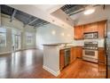 Open kitchen with stainless steel appliances and breakfast bar transitions to a well-lit open living space at 3920 Sharon Rd # 208, Charlotte, NC 28211