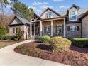 Inviting front yard showcasing a beautifully landscaped entrance, stone accents, and a classic American flag display at 462 Barber Loop, Mooresville, NC 28117