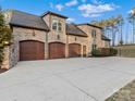 Three-car garage of a brick home, featuring wood doors and large driveway at 462 Barber Loop, Mooresville, NC 28117