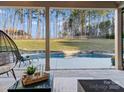 Inviting pool area with stone surround, lush green lawn, and tall trees providing privacy at 462 Barber Loop, Mooresville, NC 28117