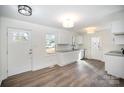 Bright, airy kitchen featuring white cabinets, granite countertops, and new wood flooring at 523 Hickory Nut Ln, China Grove, NC 28023