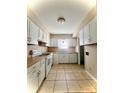 Classic kitchen featuring white appliances and neutral toned floor tiles at 5810 Hunting Ridge Ln # C, Charlotte, NC 28212
