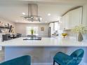 Open-concept kitchen features a spacious island with quartz countertops, stainless steel appliances and modern fixtures at 8208 Doverdale Ln, Charlotte, NC 28217