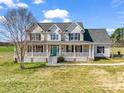 Charming two-story home with a welcoming front porch and blue door, set on a lush green lawn under a bright blue sky at 107 Sunderland Dr, Shelby, NC 28150