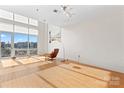A spacious and open living room with bright natural light has a floor lamp with a chair and ottoman at 1133 Metropolitan Ave # 310, Charlotte, NC 28204